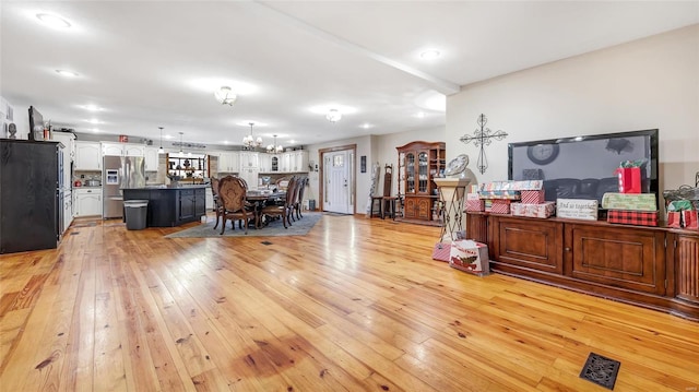 living room featuring a notable chandelier and light wood-type flooring