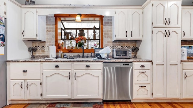 kitchen with appliances with stainless steel finishes, white cabinets, and decorative backsplash