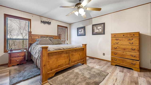 bedroom featuring crown molding, light hardwood / wood-style floors, and ceiling fan