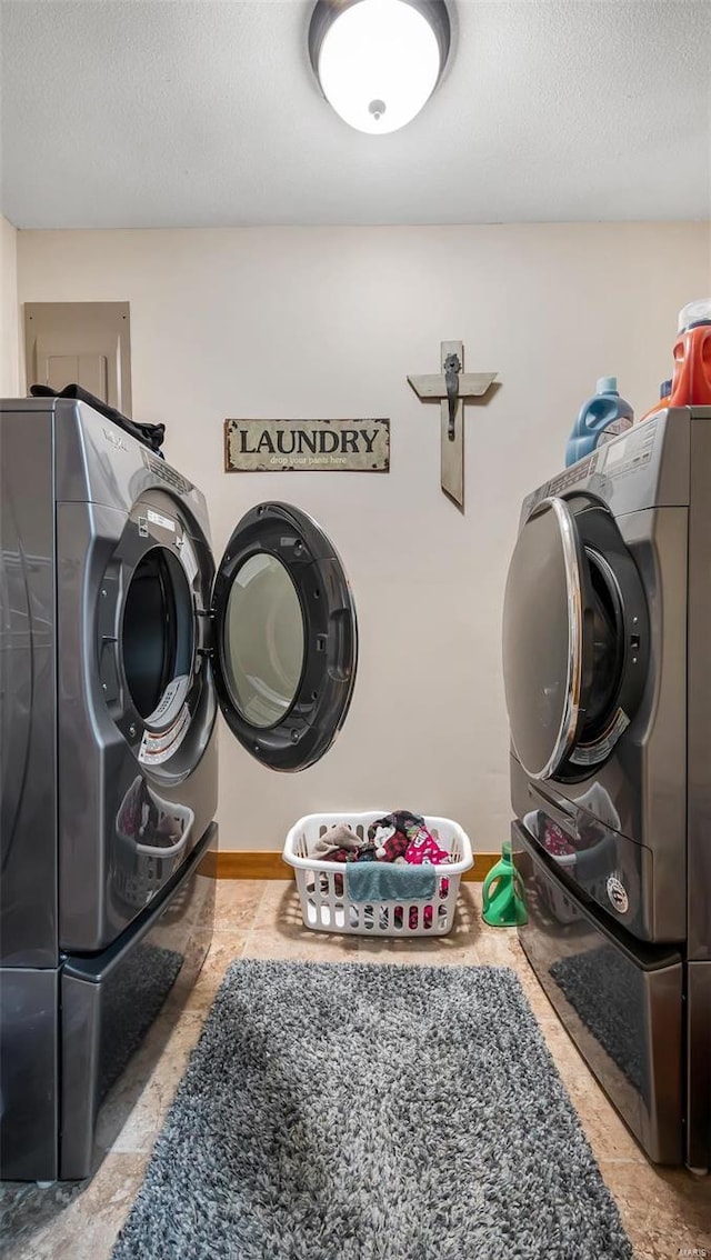 washroom with a textured ceiling and washer and clothes dryer