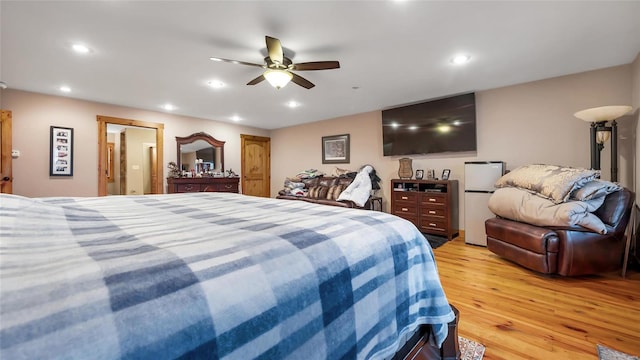 bedroom with ceiling fan, fridge, and light wood-type flooring