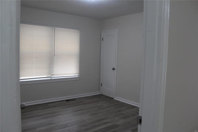 empty room featuring visible vents, baseboards, and wood finished floors