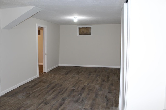 basement featuring dark hardwood / wood-style floors and a textured ceiling