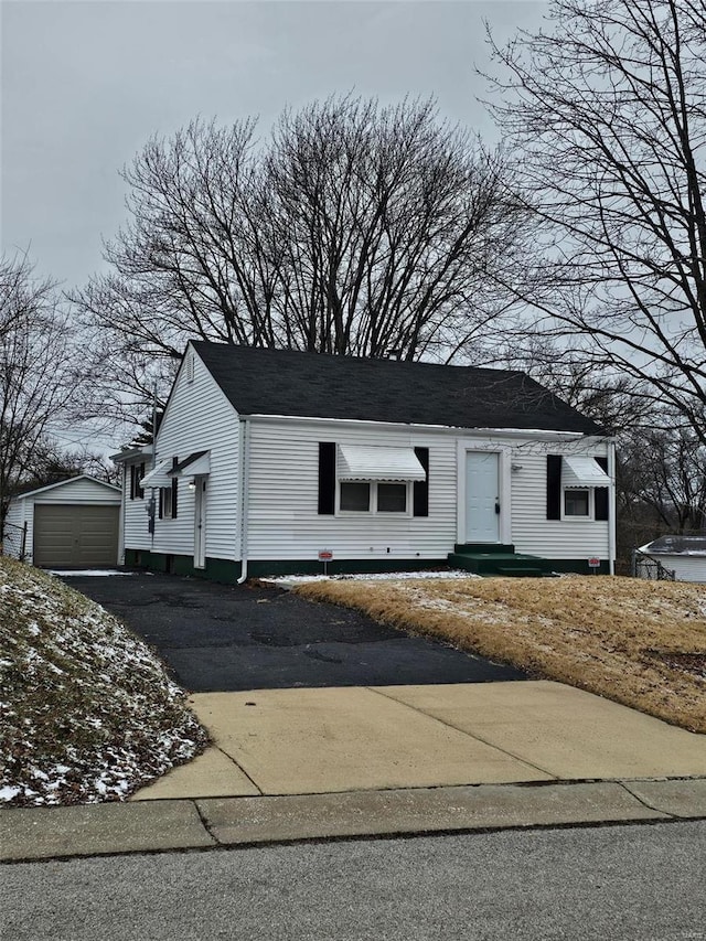 view of front of home featuring aphalt driveway, entry steps, an outdoor structure, and a garage