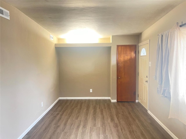 spare room with dark hardwood / wood-style flooring and a textured ceiling