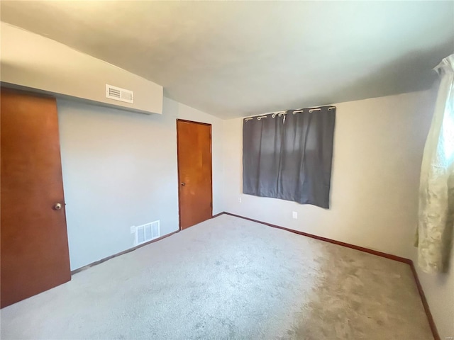 unfurnished bedroom featuring vaulted ceiling, a closet, and carpet flooring