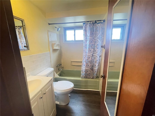 full bathroom featuring vanity, toilet, tile walls, and shower / bath combo with shower curtain