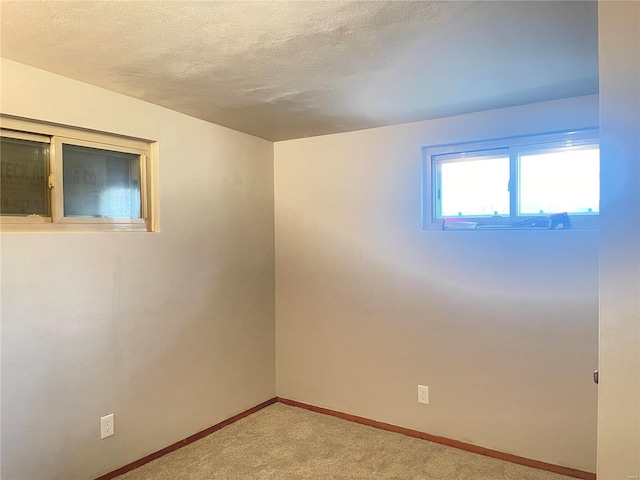 carpeted spare room featuring a textured ceiling