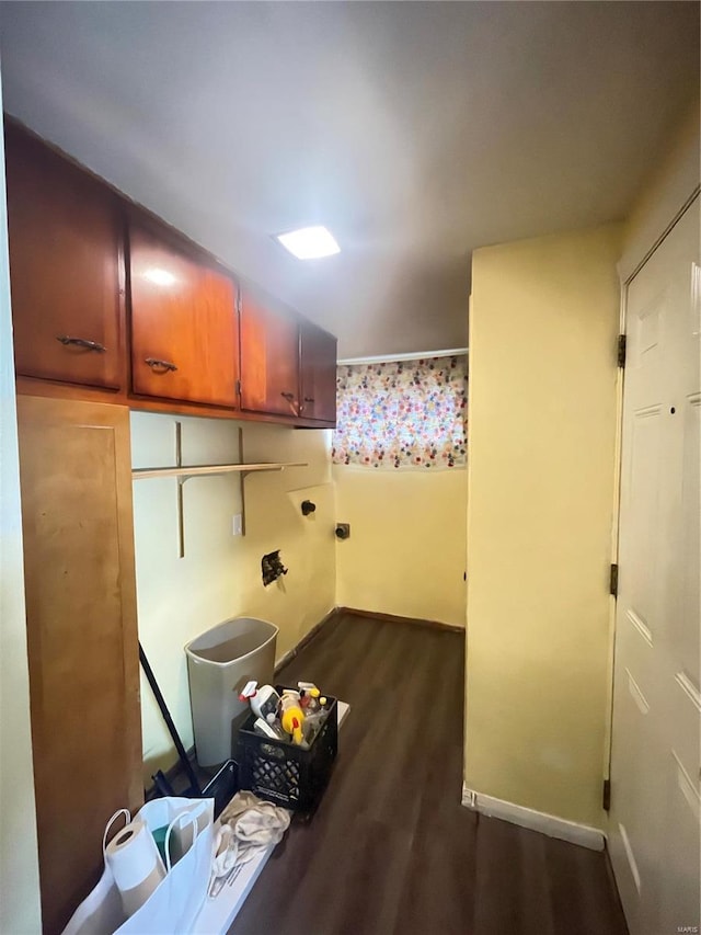 clothes washing area with cabinets and dark wood-type flooring