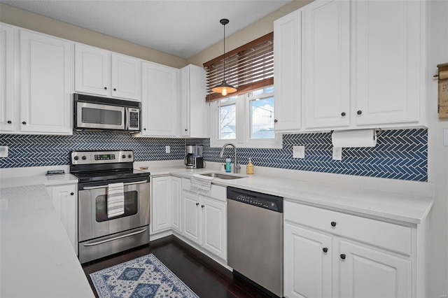 kitchen featuring sink, white cabinetry, decorative light fixtures, stainless steel appliances, and decorative backsplash