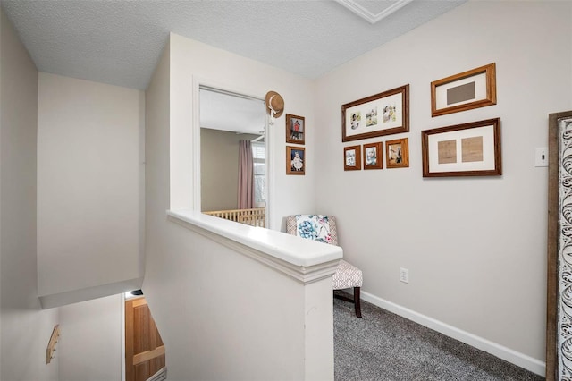 hallway featuring carpet and a textured ceiling