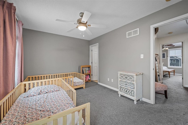 carpeted bedroom with ceiling fan and a textured ceiling