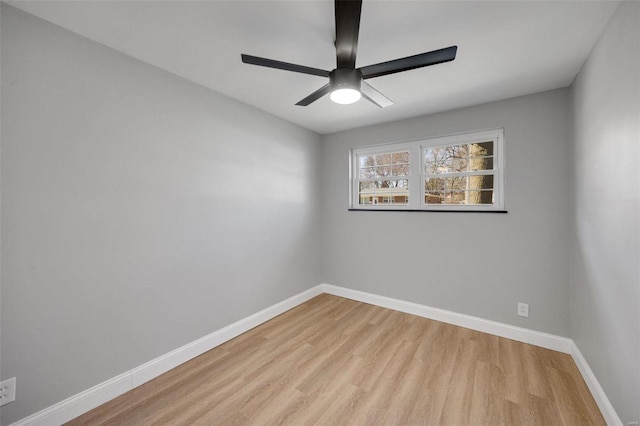 unfurnished room with wood finished floors, a ceiling fan, and baseboards