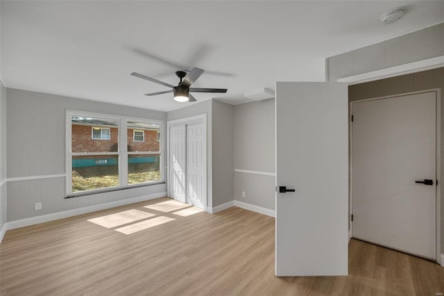 unfurnished bedroom with ceiling fan, a closet, baseboards, and wood finished floors