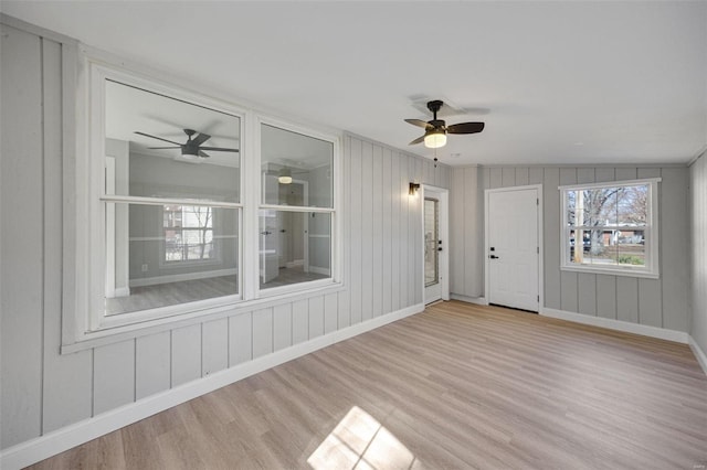 unfurnished sunroom featuring a ceiling fan