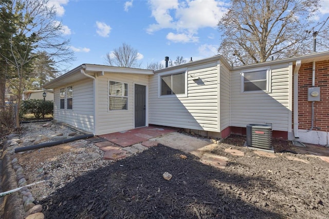 rear view of house featuring cooling unit and brick siding