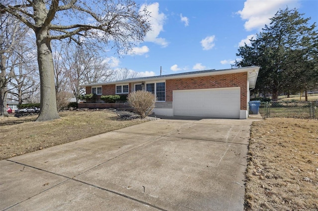 ranch-style house featuring a garage, driveway, brick siding, and fence