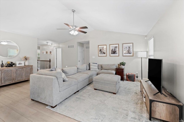 living room featuring light hardwood / wood-style flooring, vaulted ceiling, ceiling fan, and plenty of natural light