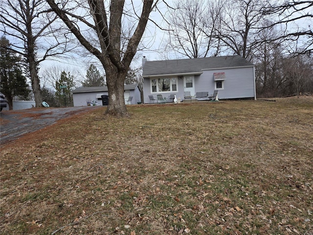 view of front of property with a garage, a chimney, and a front lawn