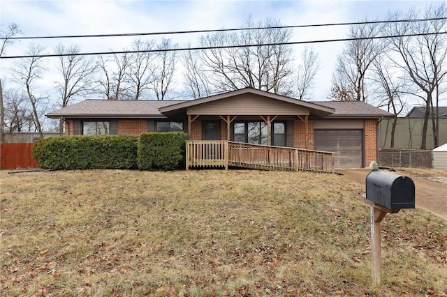 single story home featuring a garage, covered porch, and a front lawn