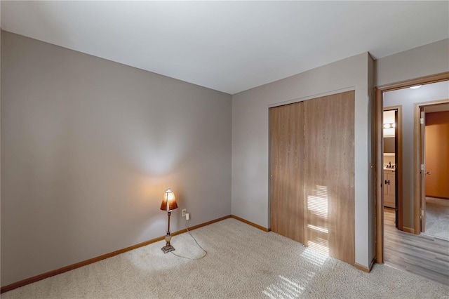 unfurnished bedroom with light colored carpet and a closet