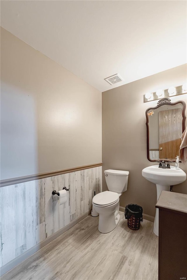 bathroom with hardwood / wood-style floors, sink, and toilet