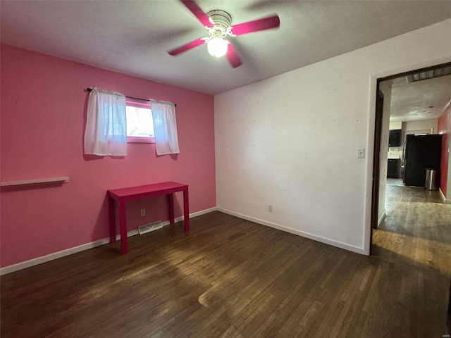 empty room with dark wood-type flooring, ceiling fan, and a textured ceiling