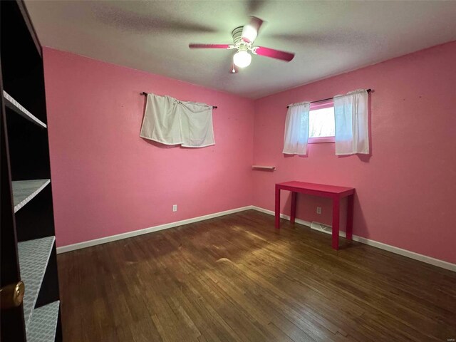 unfurnished bedroom with dark hardwood / wood-style flooring, a textured ceiling, and ceiling fan