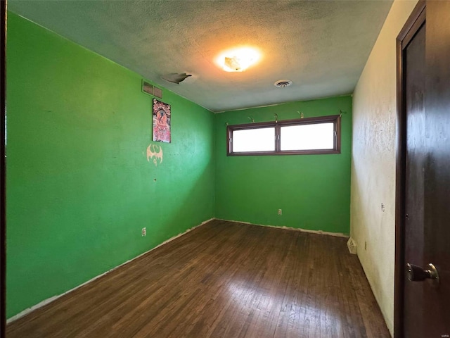 unfurnished room with dark hardwood / wood-style floors and a textured ceiling