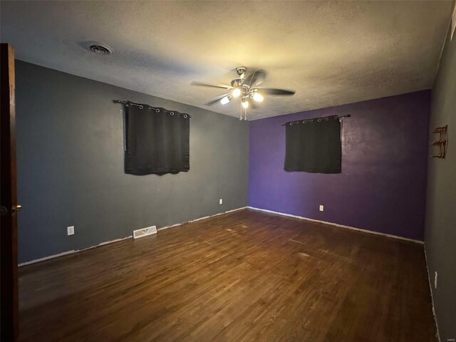 spare room featuring ceiling fan, dark hardwood / wood-style flooring, and a textured ceiling