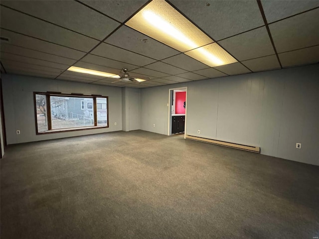 carpeted empty room featuring ceiling fan, a drop ceiling, and baseboard heating