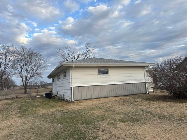 view of side of property featuring a lawn and central air condition unit