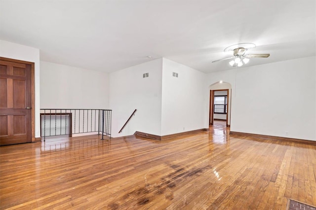 empty room with ceiling fan and light hardwood / wood-style flooring