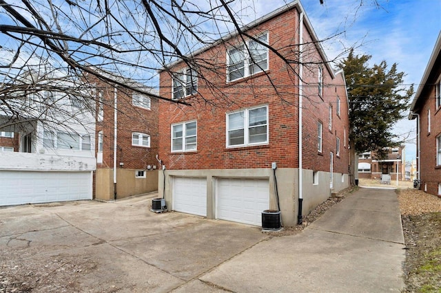 back of house with a garage and central air condition unit