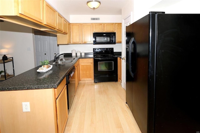 kitchen featuring sink, light brown cabinets, light wood-type flooring, and black appliances