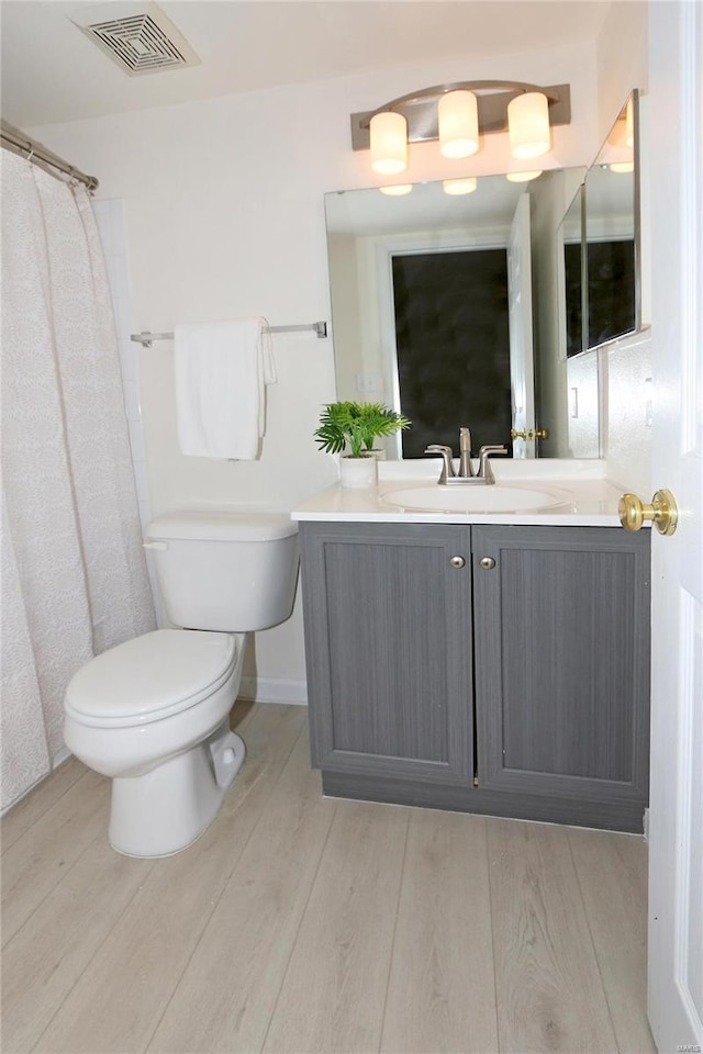 bathroom featuring hardwood / wood-style flooring, vanity, and toilet