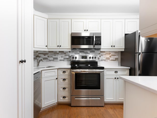 kitchen featuring white cabinetry, sink, light hardwood / wood-style flooring, and appliances with stainless steel finishes