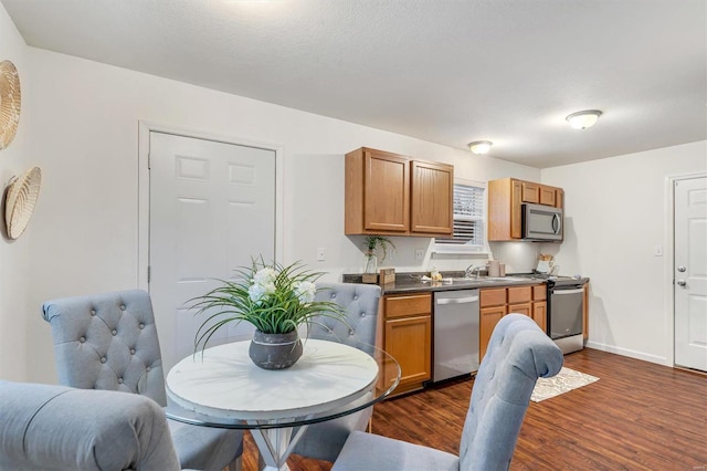 kitchen with dark hardwood / wood-style flooring, a textured ceiling, and appliances with stainless steel finishes