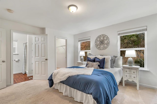 carpeted bedroom featuring a walk in closet