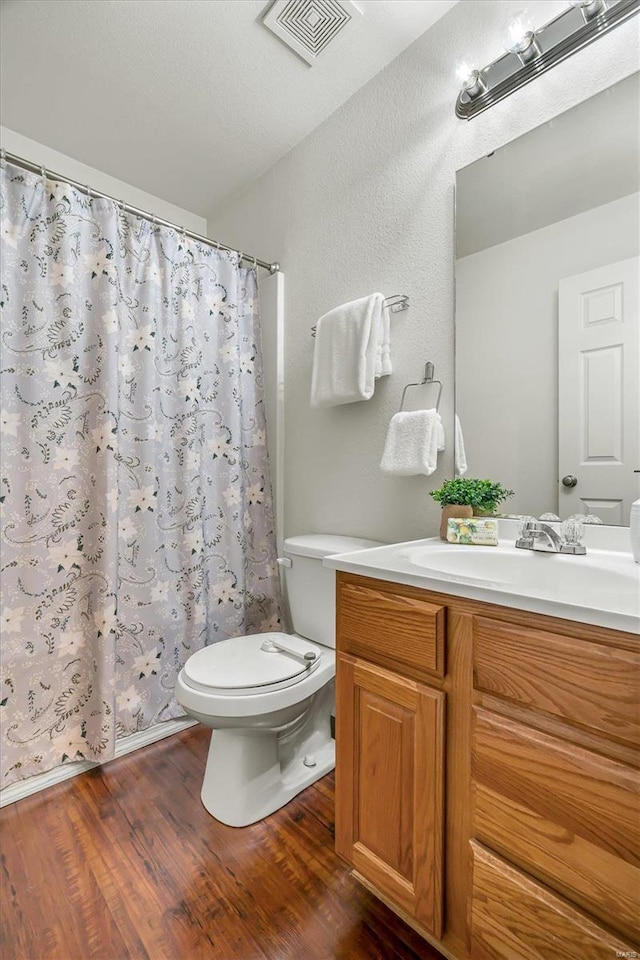 bathroom featuring vanity, hardwood / wood-style flooring, and toilet