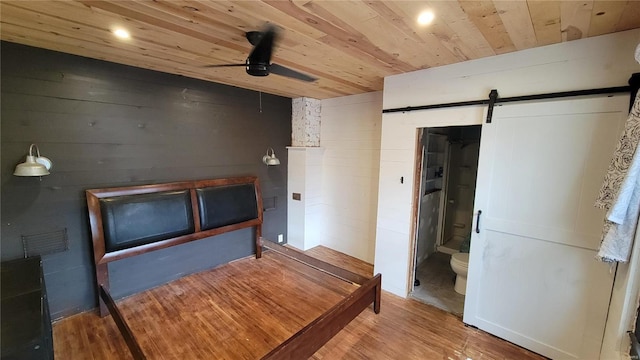 interior space featuring a barn door, hardwood / wood-style floors, and wooden ceiling