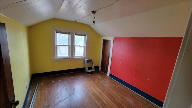 bonus room with heating unit, dark wood-type flooring, and vaulted ceiling