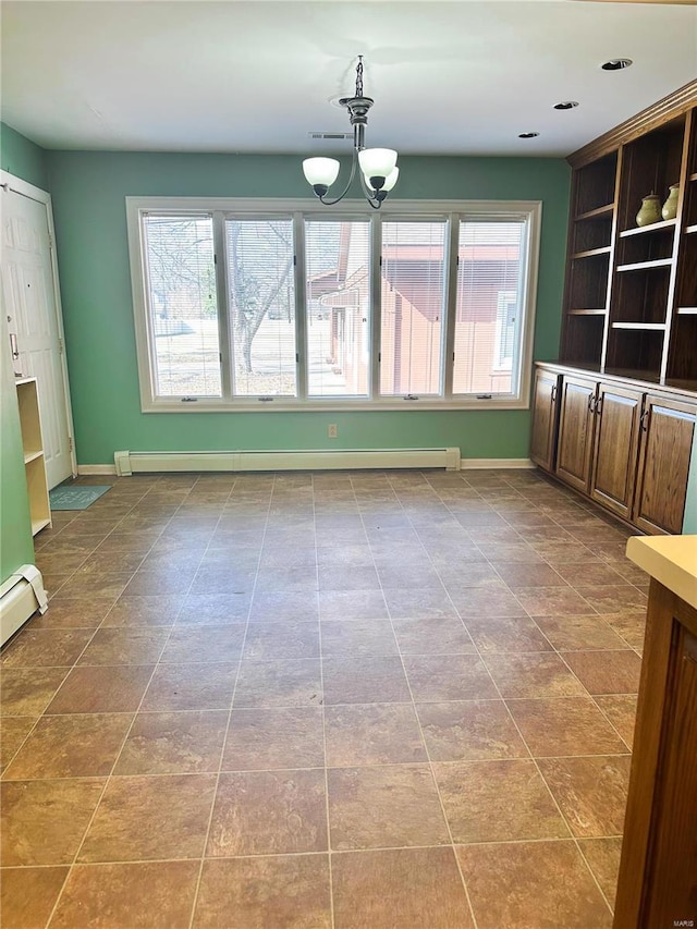 interior space with a notable chandelier, a baseboard radiator, and baseboards