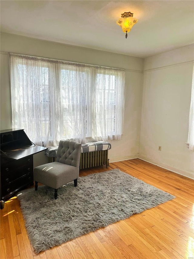 sitting room with baseboards and wood finished floors