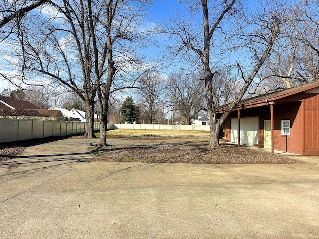 view of yard featuring fence and concrete driveway