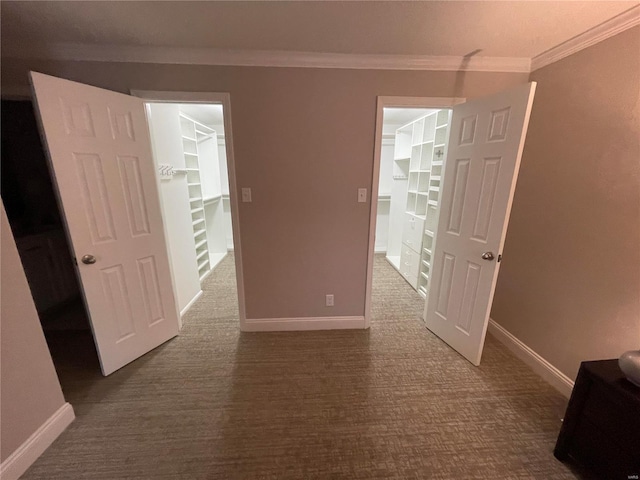 empty room featuring dark carpet and ornamental molding