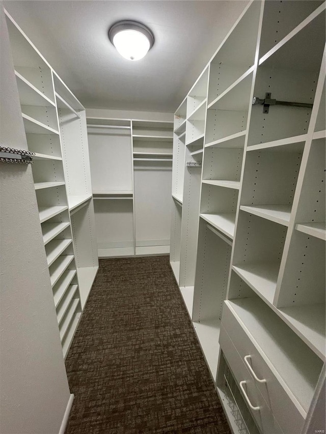 spacious closet featuring dark carpet