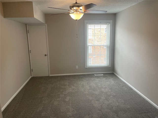 carpeted empty room featuring ceiling fan and a textured ceiling