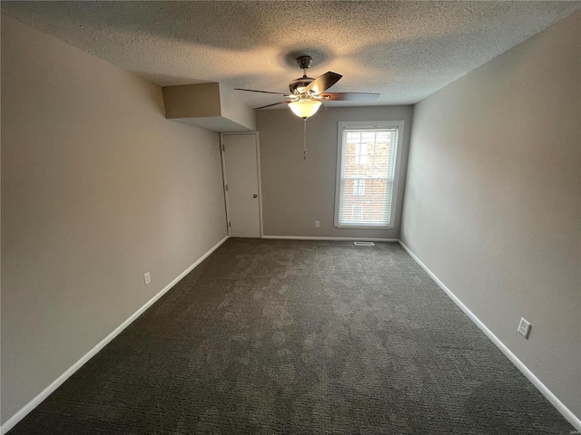 unfurnished room featuring a textured ceiling, ceiling fan, and dark colored carpet