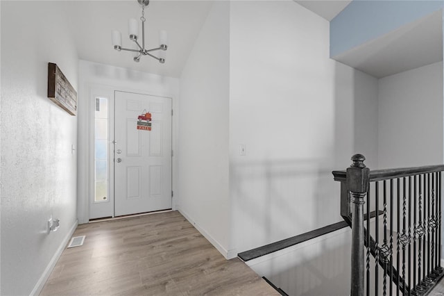 foyer with an inviting chandelier and light hardwood / wood-style flooring